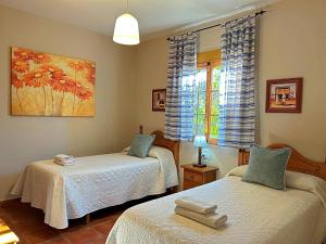 une chambre avec deux lits et une fenêtre dans l'établissement Casa Laguna del Maiz cazorla, à Burunchel