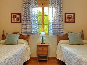 deux lits jumeaux dans une chambre avec fenêtre dans l'établissement Casa Laguna del Maiz cazorla, à Burunchel