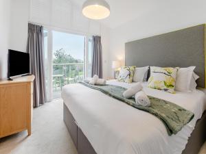 a bedroom with a large bed with a large window at Lodge 52 Una in Carbis Bay