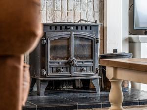 une personne regardant un poêle dans une pièce dans l'établissement Kildonan, à Durnamuck