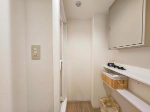 a small bathroom with white walls and a white cabinet at Hermitage Hotel Nishishin in Tokyo +114 photos