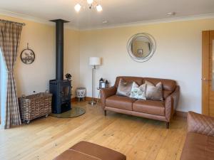 un soggiorno con divano e stufa a legna. di Trelaw - Uk41532 a Ochiltree