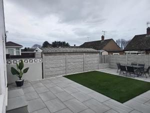 a backyard with a patio with a green lawn at 58 Clifton Rise in Abergele