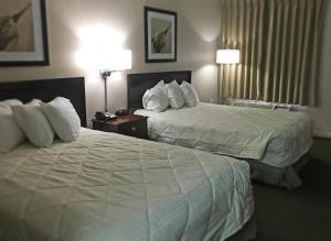 a hotel room with two beds and two lamps at Inn of Clanton in Clanton