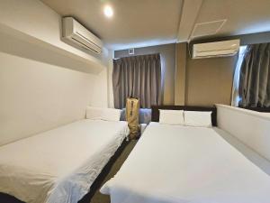a room with two beds in a room with at Hermitage Hotel Nishishin in Tokyo