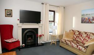 ein Wohnzimmer mit Couch und Kamin in der Unterkunft The Farmhouse in Moyle