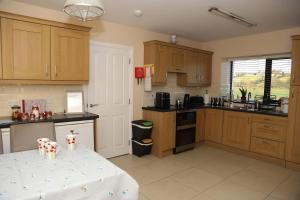 eine Küche mit Holzschränken und einem Tisch darin in der Unterkunft The Farmhouse in Moyle