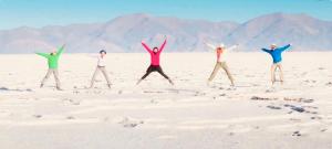 un gruppo di quattro persone che saltano sulla sabbia di Jujuy internacional AirPort a El Carmen