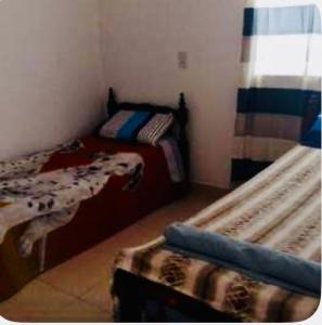 una piccola camera da letto con due letti e una finestra di Jujuy internacional AirPort a El Carmen