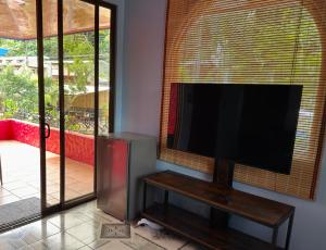 a flat screen tv in a living room with a window at Hotel Carmen Costa Coral in Tambor