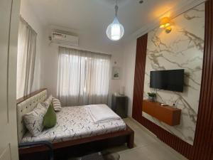 een kleine slaapkamer met een bed en een televisie bij Trevors Home Place in Lagos