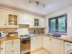 a kitchen with white cabinets and a stove top oven at River View in Wadebridge