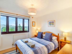 a bedroom with a bed and a large window at River View in Wadebridge +7 photos