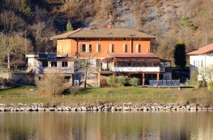 een groot huis naast een waterlichaam bij Locanda alla Grotta in Crone
