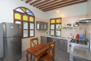 eine Küche mit Tisch und Edelstahlkühlschrank in der Unterkunft Majani Breeze in Nungwi