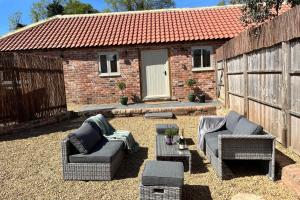 eine Terrasse mit zwei Sofas und einem Tisch vor einem Gebäude in der Unterkunft Coach Lodge in Torworth