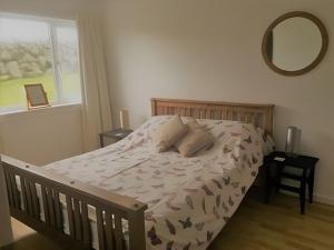 una camera da letto con un letto, uno specchio e una finestra di Erisgeir a Dearg Phort