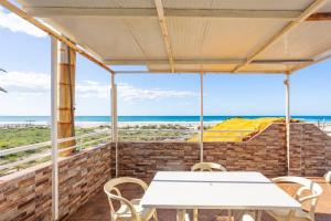 einen Tisch und Stühle auf einer Terrasse mit Blick auf den Strand in der Unterkunft María Luisa Gran Sol Beach in Zahara de los Atunes