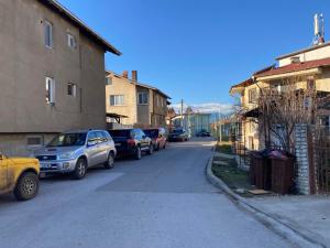 eine Straße mit am Straßenrand geparkten Autos in der Unterkunft Студио за гости Петрови in Bansko