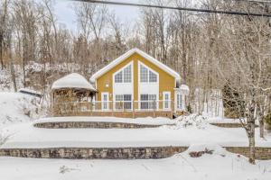 ein gelbes Haus im Schnee mit einem Teich in der Unterkunft Spa Lake - Naturo lac Sept-Iles in Saint-Raymond