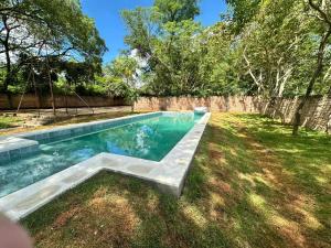 ein Pool mit einer Bank im Hof in der Unterkunft Lo de Ati Sanber in San Bernardino
