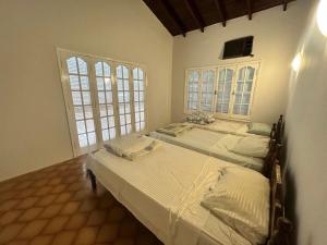 zwei Betten in einem Zimmer mit zwei Fenstern in der Unterkunft Lo de Ati Sanber in San Bernardino