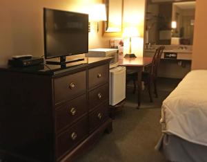 a hotel room with a dresser with a television on it at Inn of Clanton in Clanton