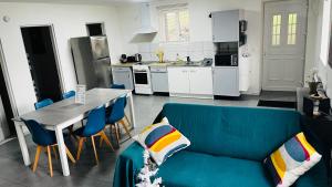 een woonkamer met een blauwe bank en een keuken bij les gîtes d'en Julio in Puylaurens