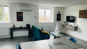 een woonkamer met een tafel en blauwe stoelen bij les gîtes d'en Julio in Puylaurens