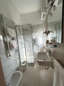 een witte badkamer met een wastafel en een spiegel bij Hotel Marchina in Brescia +62 foto's