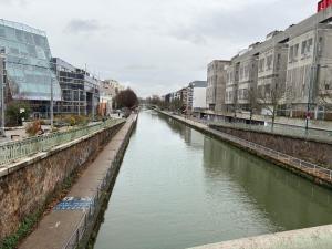 a river in the middle of a city with buildings at Studio number 9 in Pantin