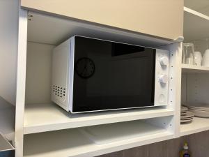 a microwave on a shelf with a clock on it at Studio number 9 in Pantin +47 photos