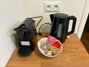 affeepot and a coffee maker on a table with a bowl of food at Studio number 9 in Pantin
