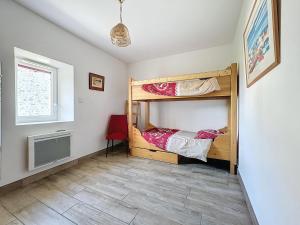a bedroom with two bunk beds and a red chair at Le Baco, gîte à la ferme in Coublevie