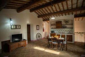 een woonkamer met een tafel en een keuken bij Re Artù Assisi Country Lifestyle in Assisi