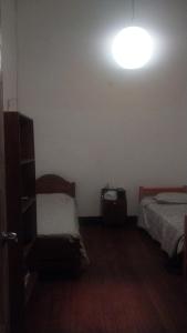 a bedroom with two beds and a light on the wall at Azul Profundo Hostal Cultural in Valparaíso