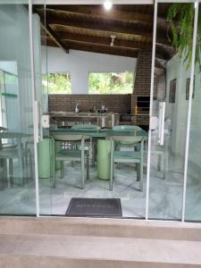 a dining room with glass doors and tables at Lugar Acolhedor e Próximo a Natureza in Florianópolis