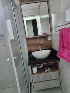 a bathroom with a sink and a glass shower at Lugar Acolhedor e Próximo a Natureza in Florianópolis +21 photos