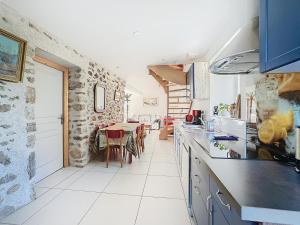 a kitchen with a counter and a dining room at Le Baco, gîte à la ferme in Coublevie