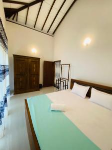 een slaapkamer met een groot bed en een stoel bij Villa Chingu in Kamburugamuwa +25 foto's