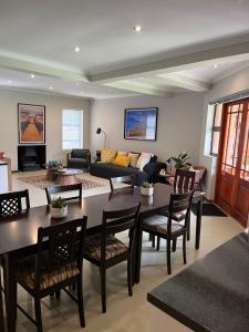 een woonkamer met een tafel, stoelen en een bank bij Tambula Guest House in Cape Town