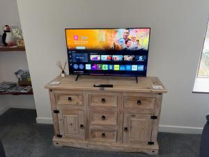 een flatscreen-tv bovenop een houten kast bij Withi-Gill in Navershaw