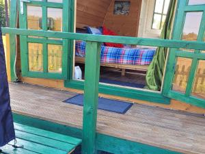 a front porch of a house with a green railing at St Austell Glamping in Lanivet