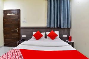 una camera da letto con un letto grande con cuscini rossi di Hotel O Pink Orchid a Kota