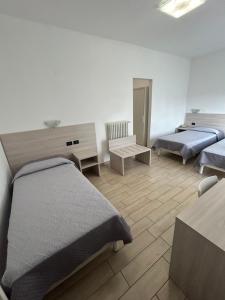 een slaapkamer met twee bedden, een bureau en een tafel bij Hotel Marchina in Brescia