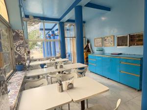 a classroom with tables and chairs and blue cabinets at Tara Guest House in Bodh Gaya