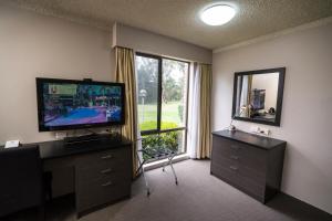 a living room with a television and a large window at The Galaxy Motel in Gosford