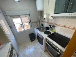 a small kitchen with a sink and a stove at Piso en Calle Albares De La Ribera in Madrid +7 photos