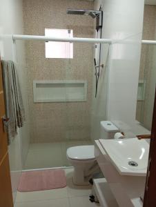 een badkamer met een douche, een toilet en een wastafel bij Pousada Flor de Caroá in Piranhas