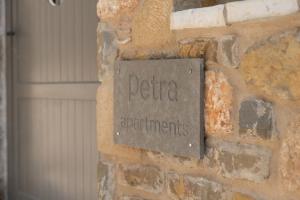 a sign on the side of a brick wall at petra apartments apartment No3 in Methoni